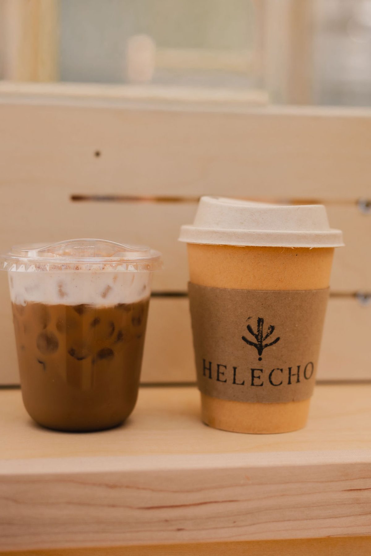 An iced coffee and a hot cup side by side on the crate