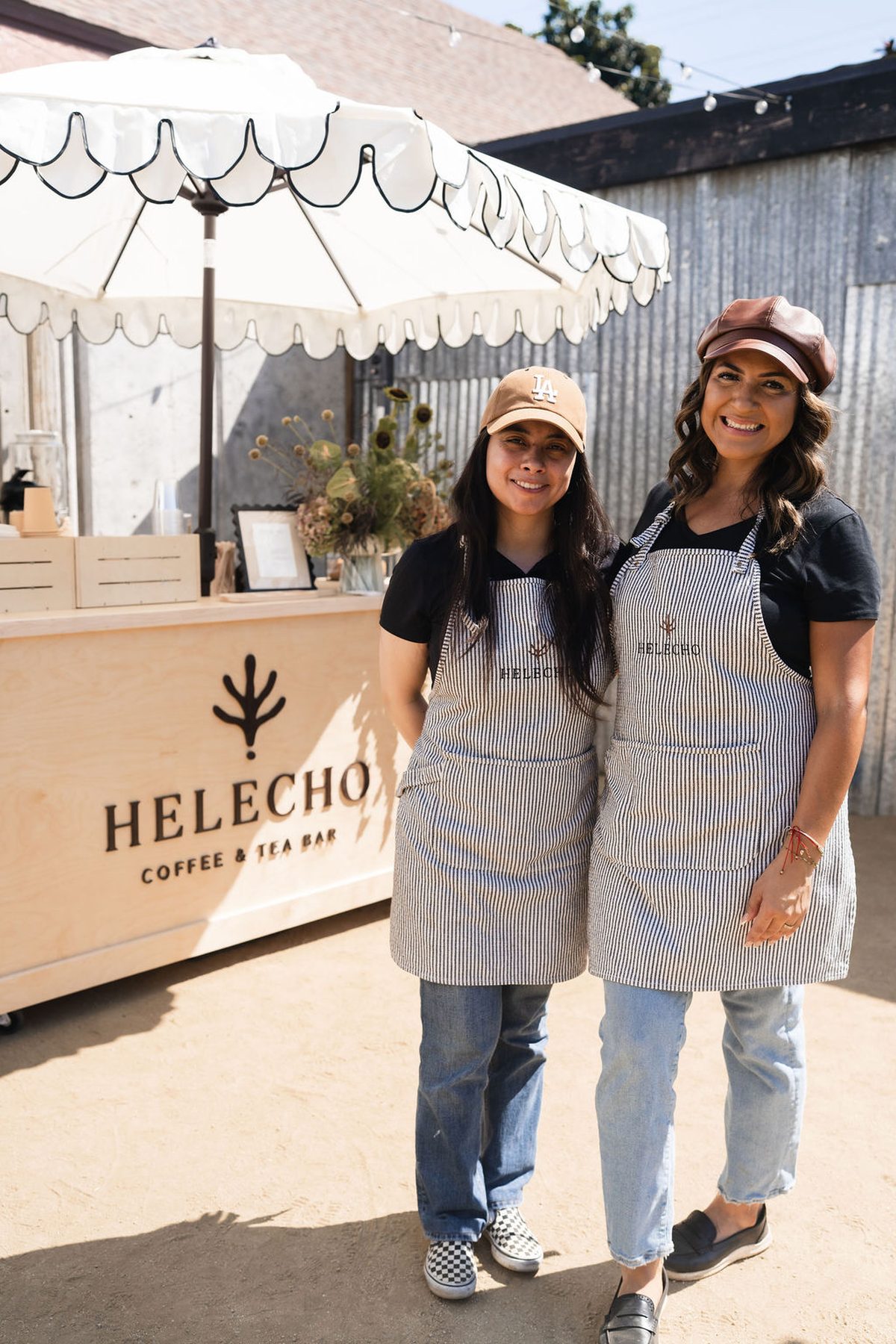 Two of us in Helecho aprons in front of the cart